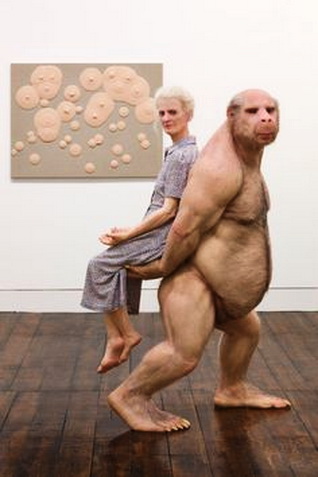 Patricia Piccinini, menos apasionada, prefiere ser cargada por una de sus esculturas gigantes hiperrealistas.